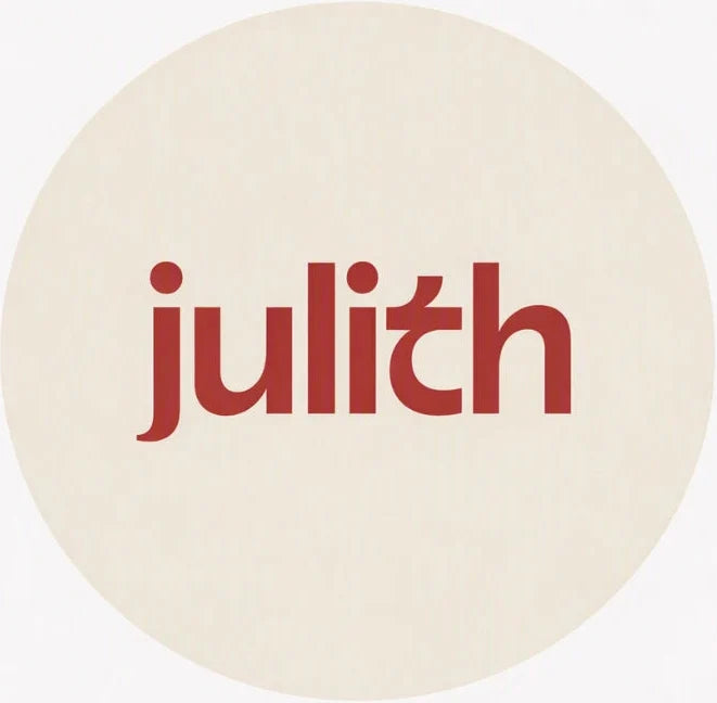 A minimalist square art print featuring the lowercase word 'julith' in a muted red serif font, centered inside a large cream-colored circle on a white square background.