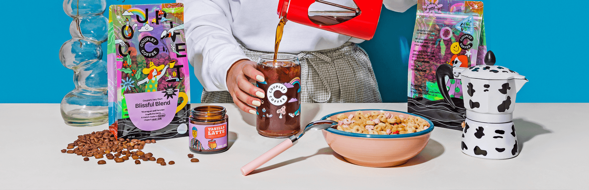 A person pouring coffee into a glass with coffee beans and breakfast items, showcasing Dubai's vibrant drinkware and accessories.