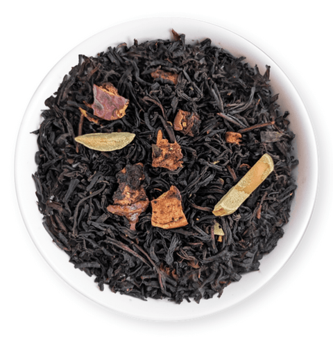 Close-up of Oh Christmas Blend black tea with apple pieces and spices in a white bowl, showcasing festive flavors.