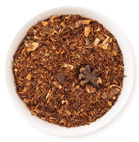 Bowl of aromatic rooibos tea blend with ginger and spices, perfect for holiday enjoyment.