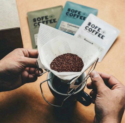 SOFE COFFEE cold brew coffee bag with freshly ground coffee brewing in a reusable pour-over filter over a cup