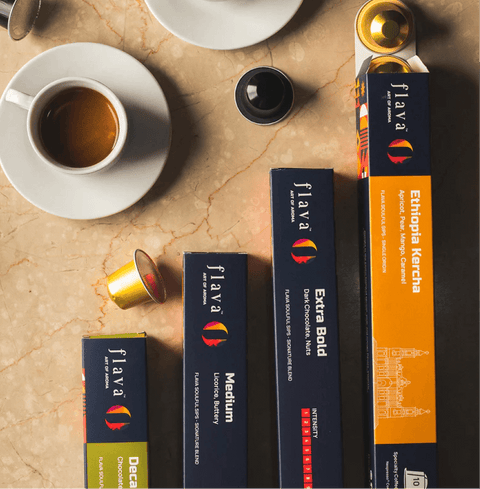 Colombian Decaf Specialty Coffee Capsules alongside other Flava coffee boxes on a marble background.