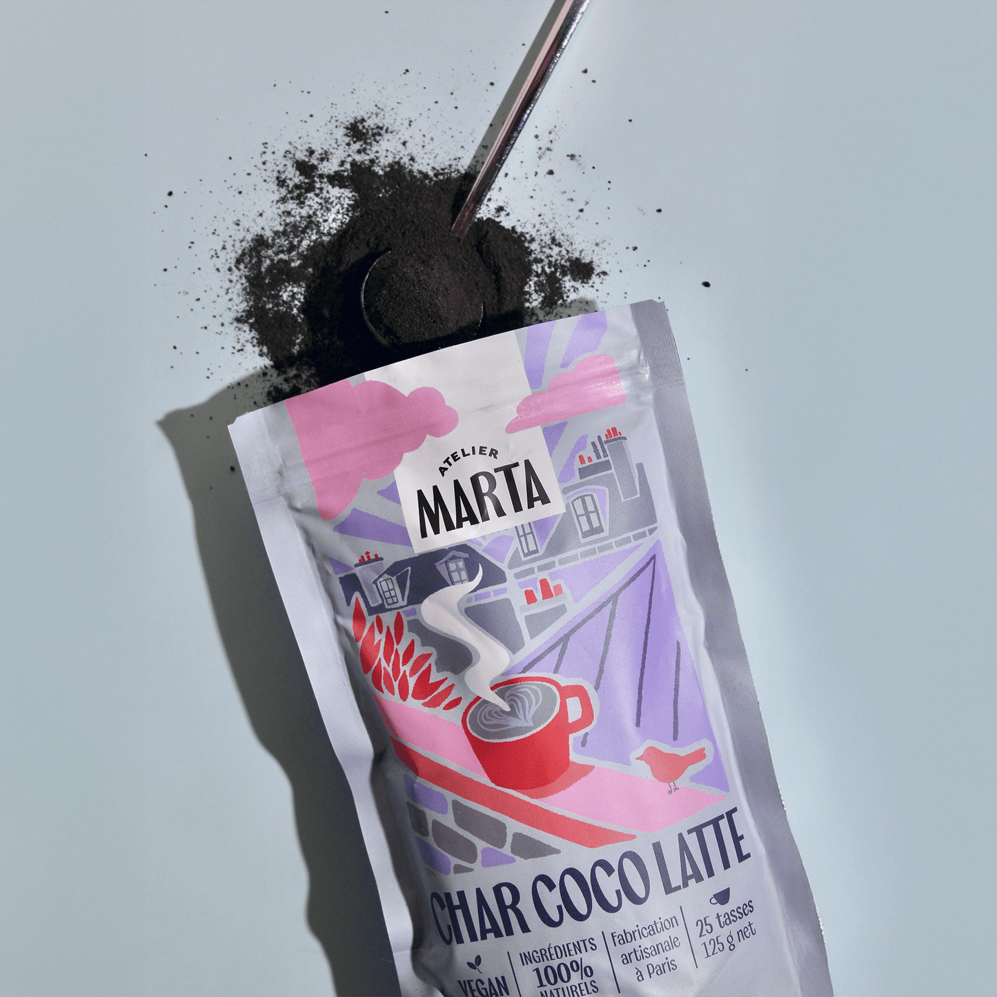 Image of Char-coco Latte powder package with activated charcoal on a spoon, promoting a detox beverage experience.
