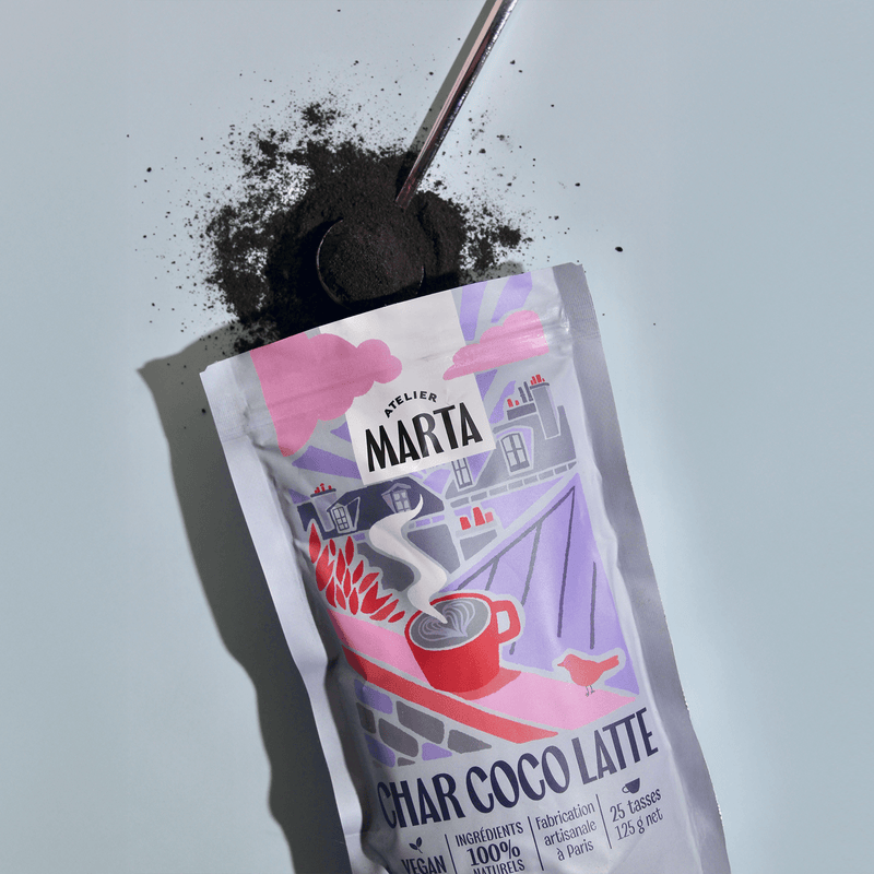 Image of Char-coco Latte powder package with activated charcoal on a spoon, promoting a detox beverage experience.