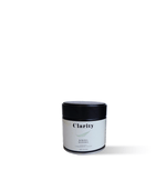 Clarity Koicha matcha green tea powder in a double-walled glass bowl beside a ceremonial matcha tin, smooth and vibrant in color.