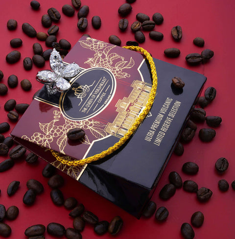 Premium ground specialty coffee box with a butterfly brooch and coffee beans on a red background.