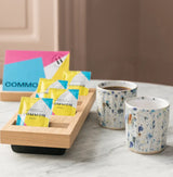 Instant Box featuring 5 sachets of instant coffee with decorative mugs on a marble surface.