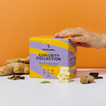 A vibrant display of Blendsmiths' Curiosity Collection, a selection of premium drinking chocolate, matcha chai, and superfood blends. A hand is holding a Japanese Matcha Blend sachet, while a stack of other flavored sachets, including Original Choc Blend,