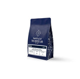 The Coffee Lab Decaf coffee beans in dark blue packaging, featuring Colombian decaffeinated specialty coffee with chocolate notes, balanced body, and lively acidity.