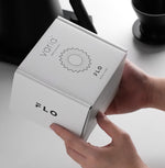 FLO 85 Paper Filters 100x packaging held in hands, featuring unique wave design and premium Japanese pulp.