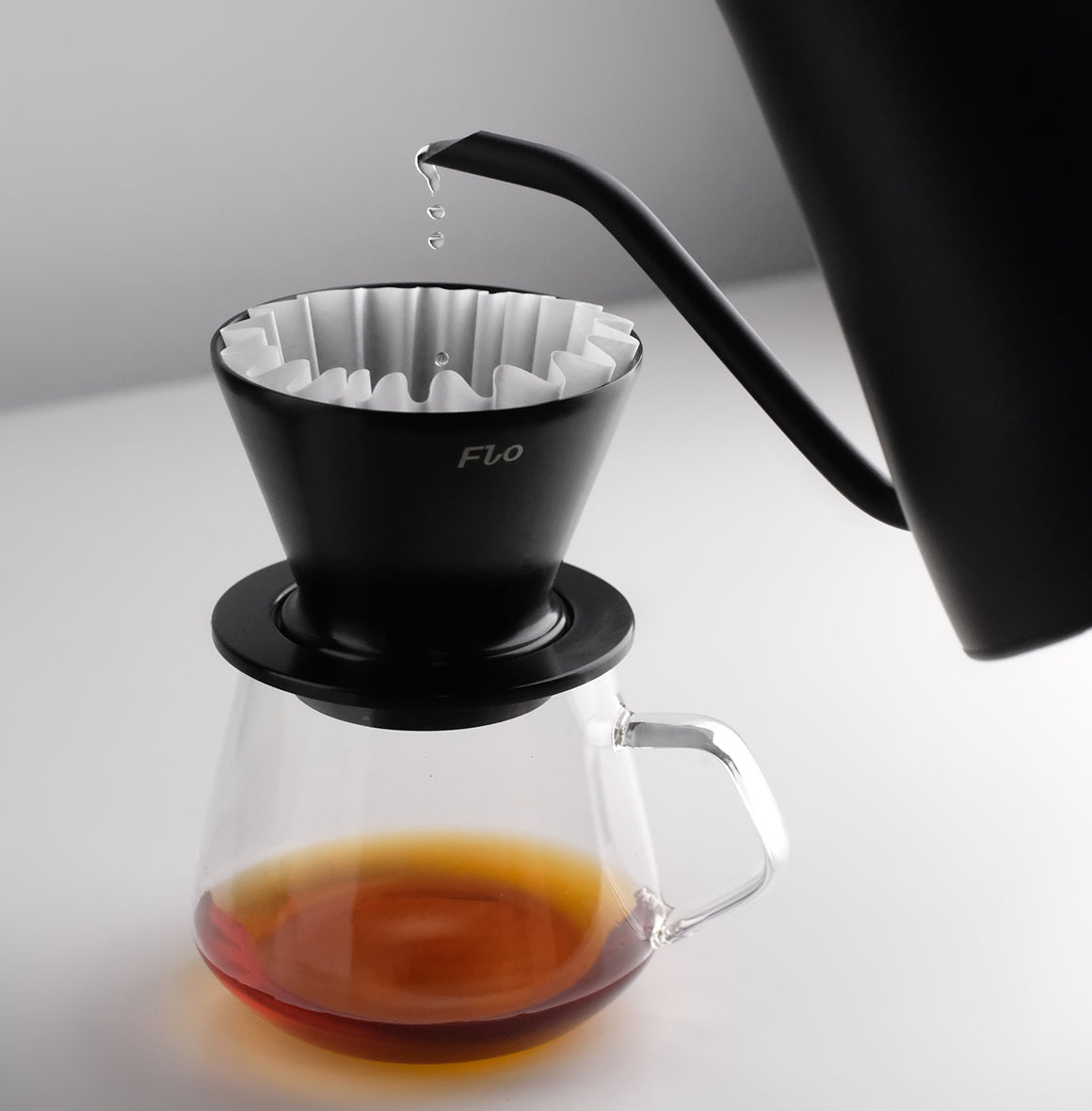 FLO 85 Paper Filters 100x used in a black dripper to brew coffee with rich aroma and flavor.