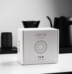 FLO 85 Paper Filters 100x packaging displayed on a modern kitchen countertop with brewing equipment.