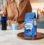 Balance Half Caf Ground Coffee by Four Sigmatic in compostable packaging, crafted with Arabica beans and wild Chaga for immune-boosting support, offering smooth energy and low-acid flavor with half the caffeine.