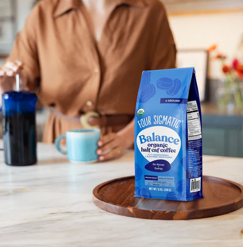 Balance Half Caf Ground Coffee by Four Sigmatic in compostable packaging, crafted with Arabica beans and wild Chaga for immune-boosting support, offering smooth energy and low-acid flavor with half the caffeine.