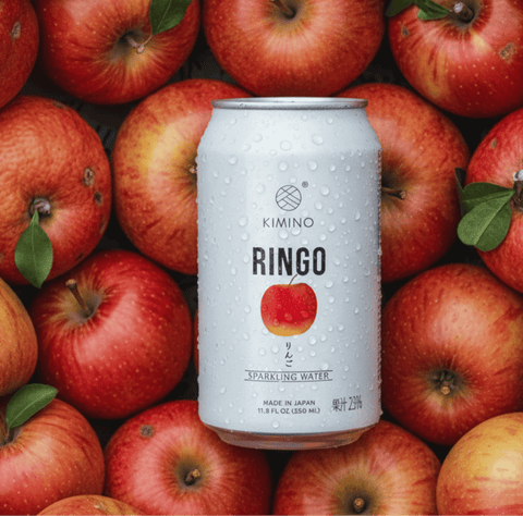 Ringo Sparkling Water can surrounded by fresh Fuji apples from Aomori, Japan, showcasing natural and crisp refreshment.