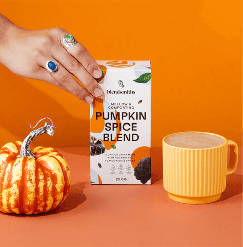 Pumpkin Spice Blend packaging with a small pumpkin and a mug of spiced drink against an orange background.