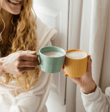 Friends enjoying warm drinks with Pumpkin Spice Blend in colorful mugs, perfect for autumn comfort.