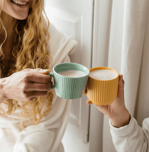 Friends enjoying warm drinks with Pumpkin Spice Blend in colorful mugs, perfect for autumn comfort.