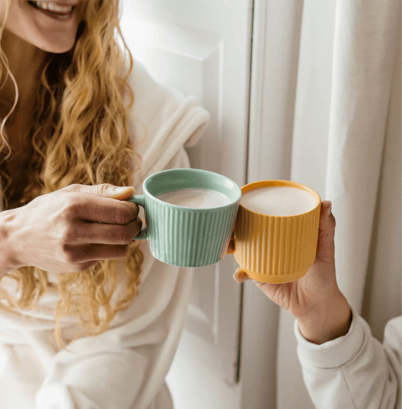 Friends enjoying warm drinks with Pumpkin Spice Blend in colorful mugs, perfect for autumn comfort.