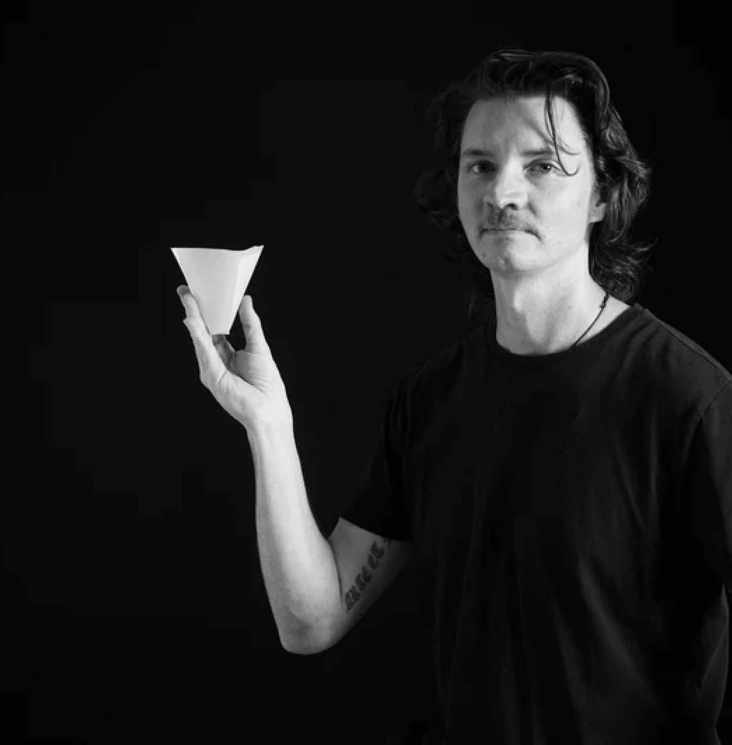 Person holding Sibarist B3 Hybrid Coffee Paper Filter in black and white image