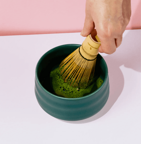 Whisking Ichibancha Ceremonial Matcha in a green bowl, showcasing vibrant first harvest matcha for traditional preparation.