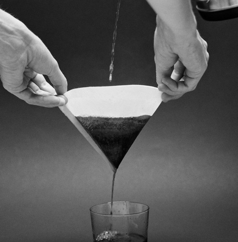 Pouring coffee through Sibarist Fast - Cone Specialty Coffee Paper Filter into a glass.