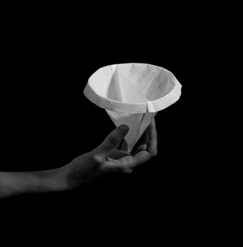 Hand holding Sibarist Fast - Dual Chamber Specialty Coffee Filters in black background