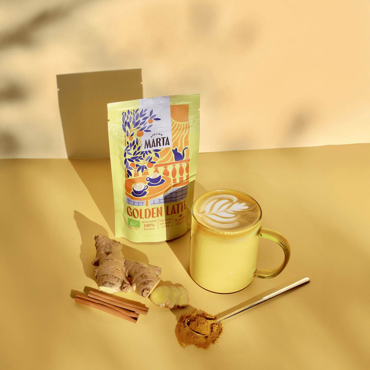 Organic Golden Latte served in a yellow mug with ginger, spices, and packaging from Atelier Marta.