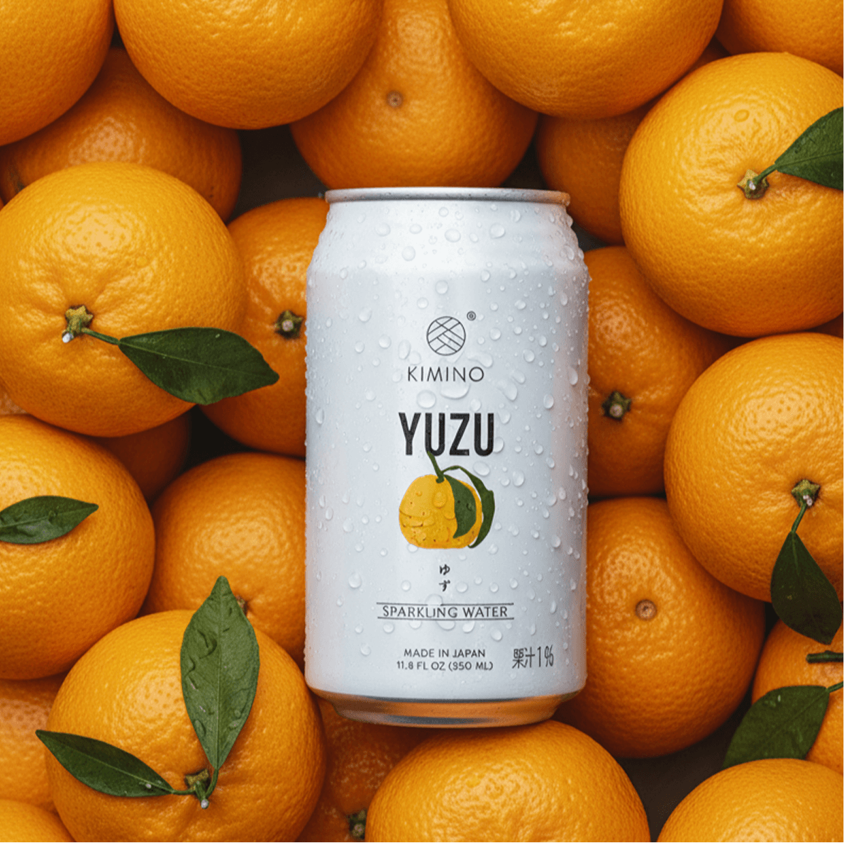 Yuzu Sparkling Water can surrounded by fresh Yuzu fruits, highlighting Kimino's citrus-infused unsweetened beverage.