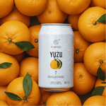 Yuzu Sparkling Water can surrounded by fresh Yuzu fruits, highlighting Kimino's citrus-infused unsweetened beverage.