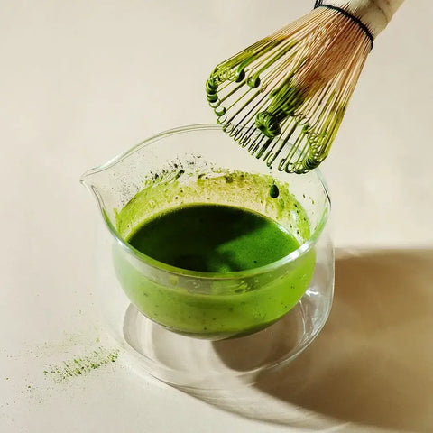 Rare Gold Matcha in glass bowl with whisk, highlighting warm deeper notes from single cultivar, single harvest roasted tencha.
