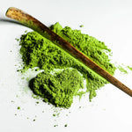Rare Gold Matcha powder with a bamboo scoop, showcasing rich green color and finely milled texture from single harvest cultivar.