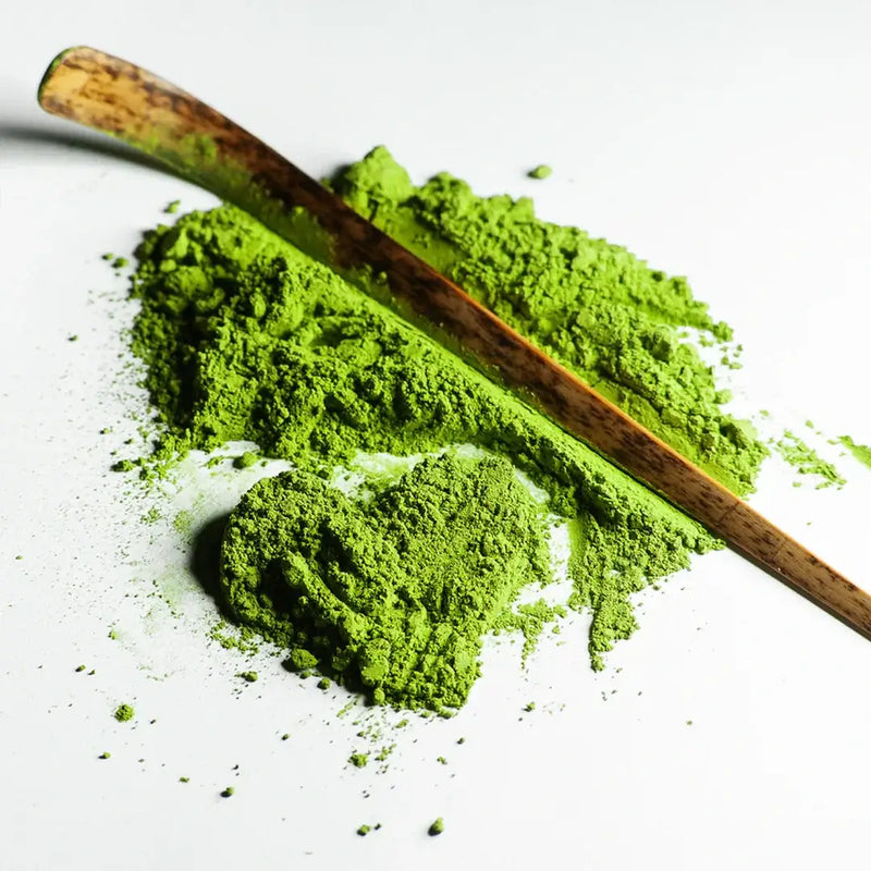 Rare Gold Matcha powder with a bamboo scoop, showcasing rich green color and finely milled texture from single harvest cultivar.