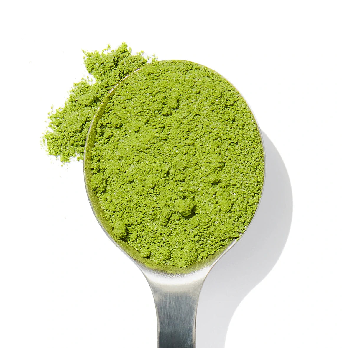 Organic flavored matcha powder in a spoon, sustainably sourced from small farms, rich in antioxidants and hand-harvested for superior quality and flavor.