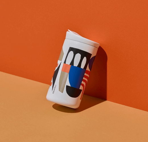 CREATED CO. City Scapes Nomad Flip 12 oz, featuring artwork by Cody Hudson, sleek white ceramic finish, leak-proof lid, and cup holder fit.