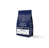 The Coffee Lab Organic Yirgacheffe coffee beans in premium dark blue packaging, featuring Ethiopian specialty coffee with milk chocolate, prune, and pomelo flavor notes.