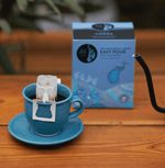 Pack of Blue Tokai Vienna Easy Pour on a table, It is a smooth dark roast coffee pack with oaky, cocoa notes and bold, heavy-bodied flavor.