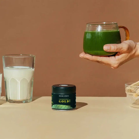 The Ceremonial Matcha Starter Bundle : Gold No.2 with matcha drink and Gold No.2 tin on a beige table.