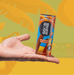 Hand holding a can of Grapefruit & Orange Sparkling Coffee - Barbados by Good Koffee, displayed against a vibrant tropical backdrop.