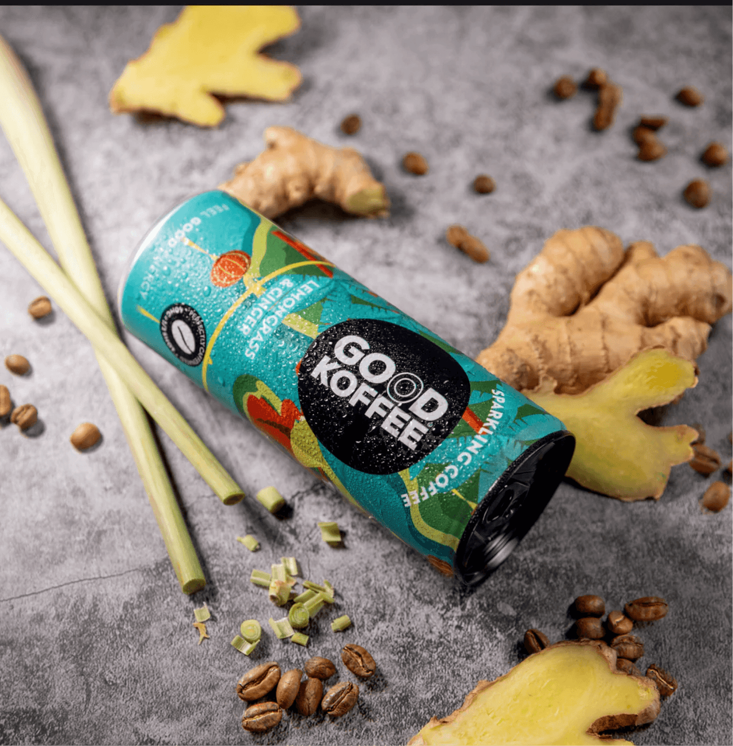 Lemongrass & Ginger Sparkling Coffee - Vietnam can surrounded by fresh lemongrass, ginger, and coffee beans on a textured surface.