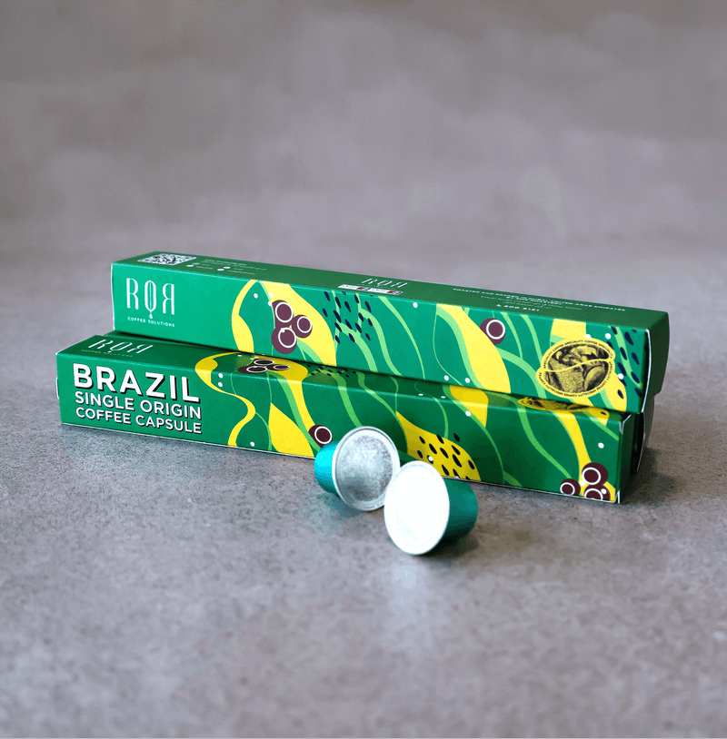 Brazil - Coffee Capsules showcasing premium Brazilian coffee in green packaging on a grey surface.