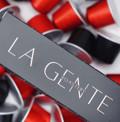 Colombia Caturra Capsules packaging with vibrant red and black coffee pods background.