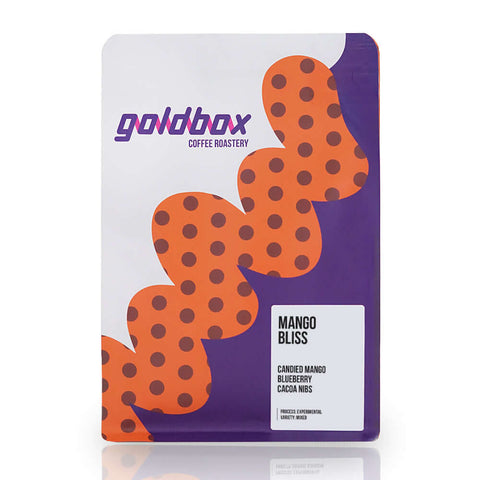 Colombia Mango Bliss coffee package with vibrant design showcasing unique flavors of mango, blueberry, and cacao nibs.