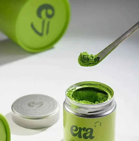 Era Dark Bamboo Chashaku — Matcha Spoon measuring matcha powder from an eco-friendly canister.