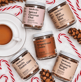 Image of various tea jars including Ginger Bread Cookies, surrounded by candy canes and a cup of tea.