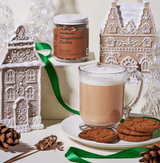Ginger Bread Cookies with a cozy cup of tea beside festive gingerbread house decor.