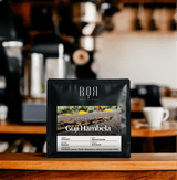 Guji Hambela Ethiopian coffee bag on a wooden counter, showcasing smallholder farming purity and balance in aroma.