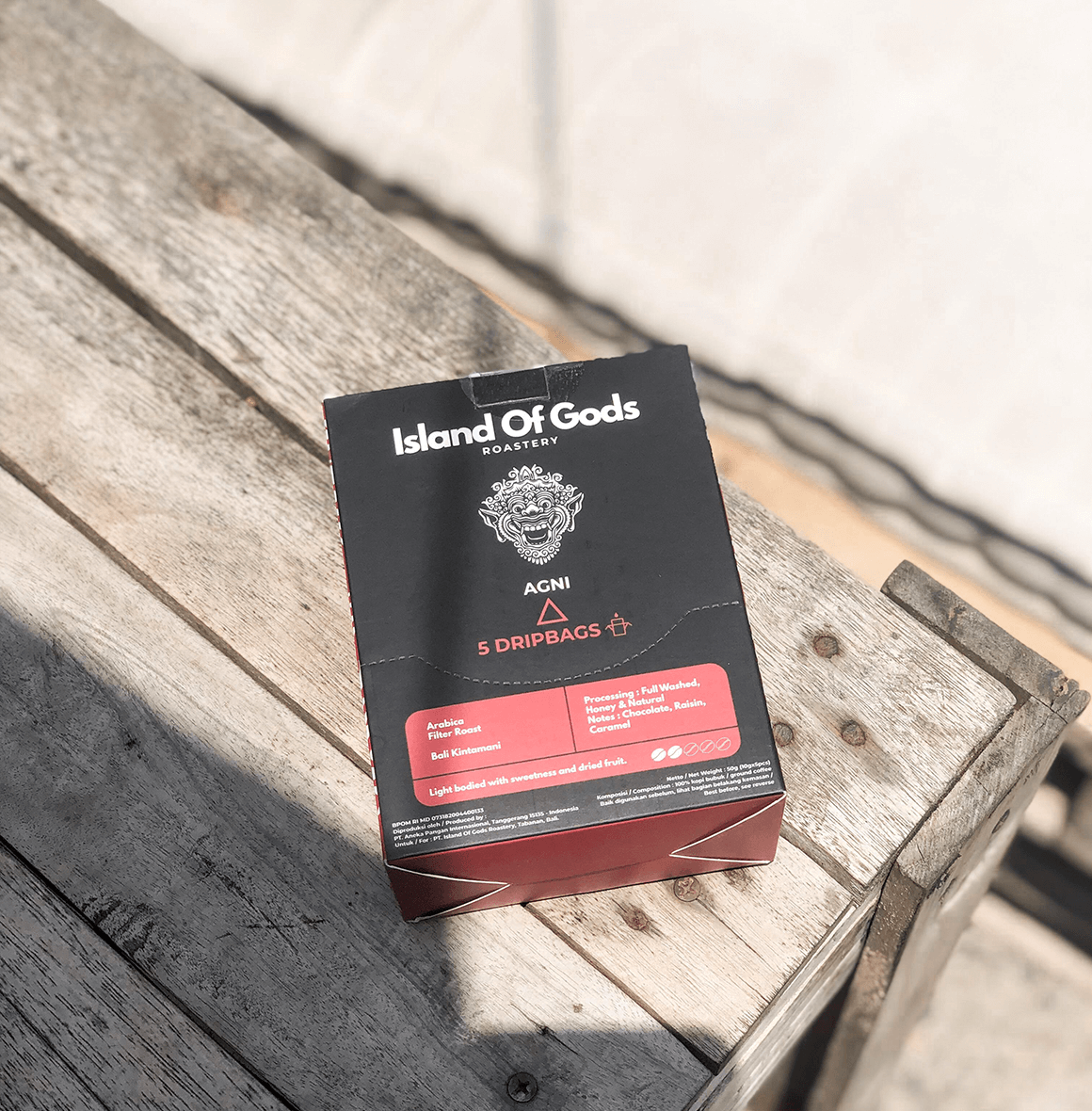 Variety of Island of Gods drip bag coffee boxes displayed on a rustic surface, showcasing vibrant packaging and flavors.