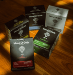 Assorted Island of Gods coffee drip bags showcasing vibrant packaging on a wooden surface.