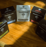 Island of Gods drip bags in various flavors showcasing vibrant packaging on a wooden surface.